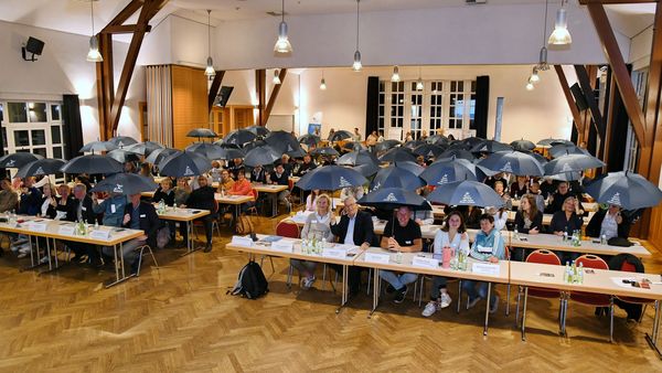 Die Teilnehmenden des Fachtages erhielten als Überraschung einen Regenschirm, den sie symbolisch als Schutzschirm aufspannten.