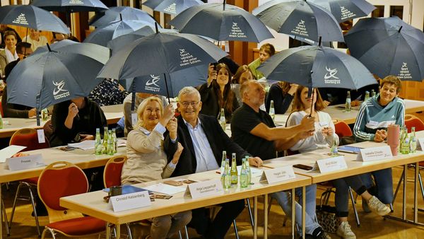 Die Zuschauer posieren mit ihren Schirmen.